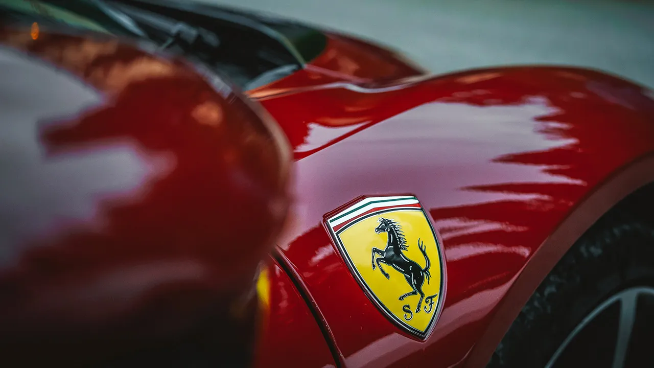 The unmistakable insignia of Scuderia Ferrari. A close up of a Ferrari badge on the flank of a red car