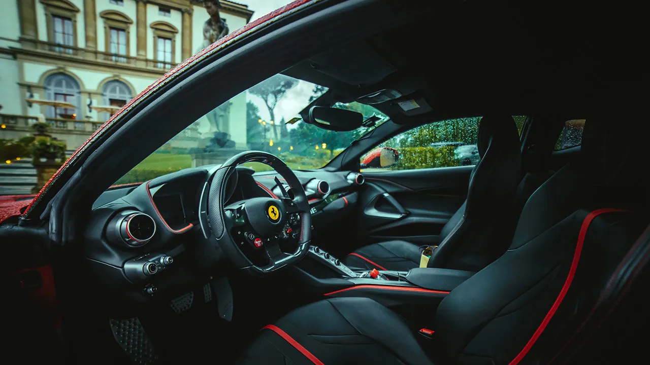 F1-inspired controls are a modern Ferrari signature. Close up of the interior of a modern supercar with black seats.